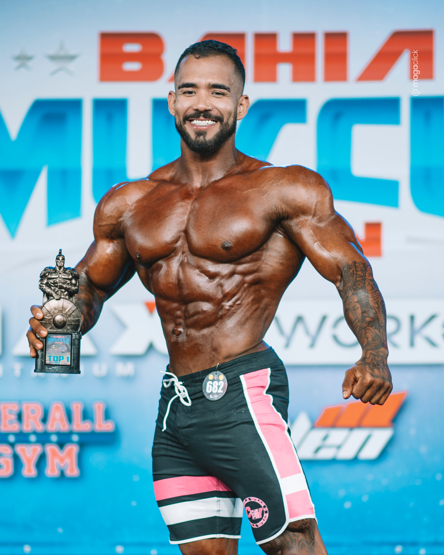 Rodolfo Ribeiro posando no palco com o troféu Top 1